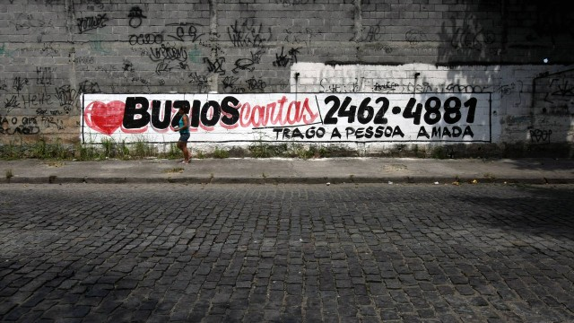 Muro na Avenida Brasil anunciando os serviços da Feiticeira da Ilha